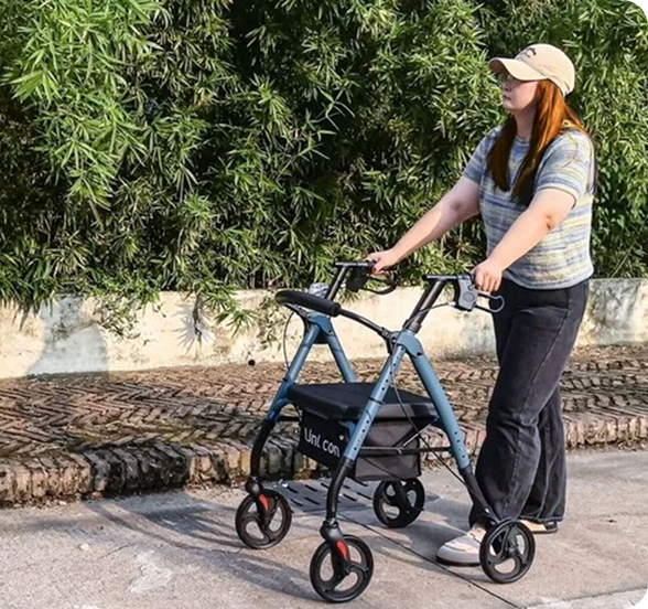 Woman walking outdoors using a blue four-wheeled rollator