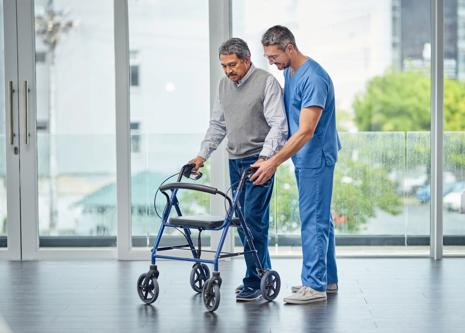Physical therapist helping a senior man use a rollator walker