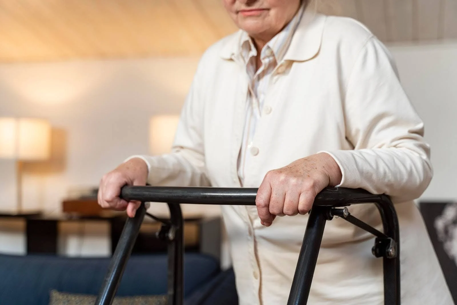 Senior woman holding a walker in a small home