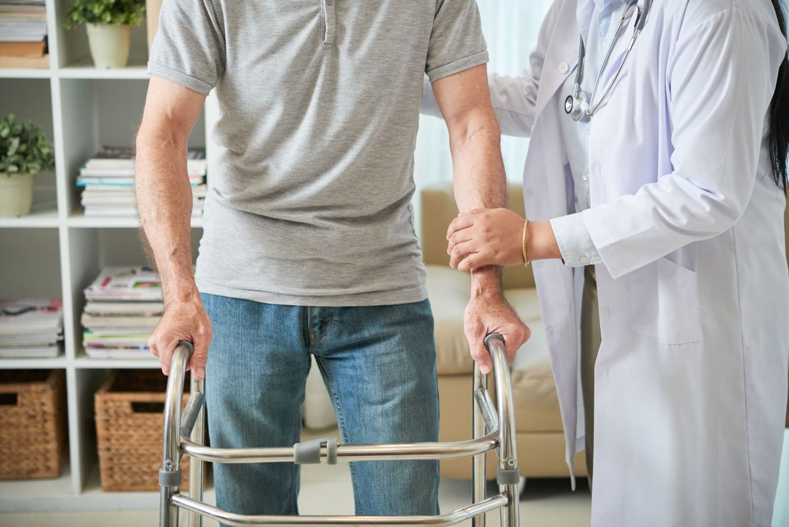 Doctor assisting an elderly patient using a walker